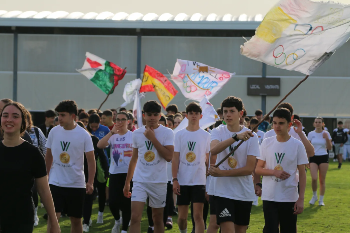 Los centros invitados entran al recinto con sus banderas